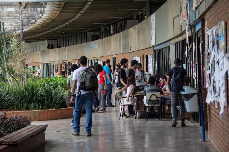 Campus universitário com alunos anadando nos corredores
