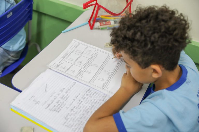 Aulo faz o dever de casa na sala de aula