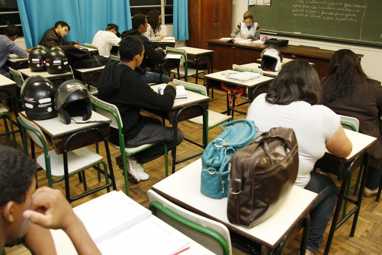 Adultos assistem aula numa sala