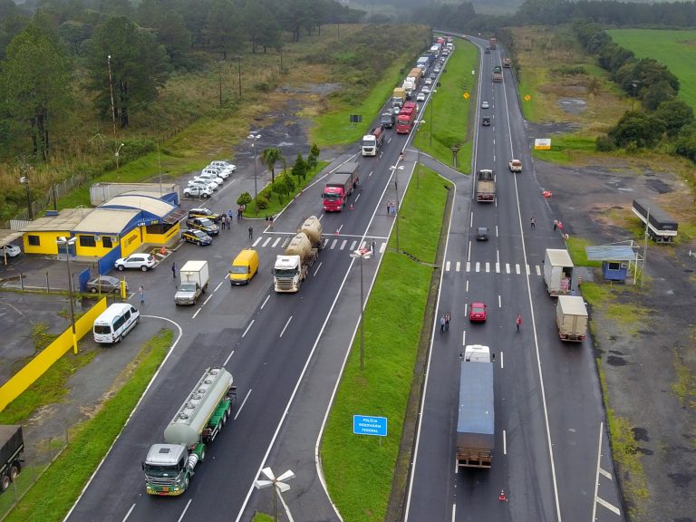 Caminhões com vários tipos de carga em rodovia no Paraná