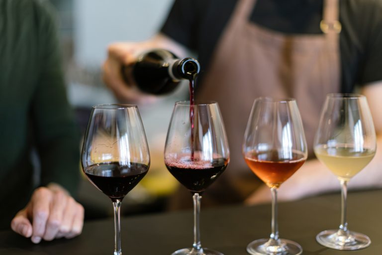 Quatro taças em cima da mesa com diferentes tipos de vinho