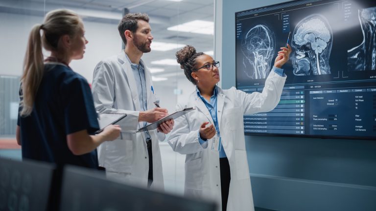Médicos examinam imagens de exame de cabeça