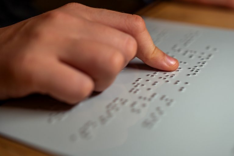 Pessoa lê texto em braille