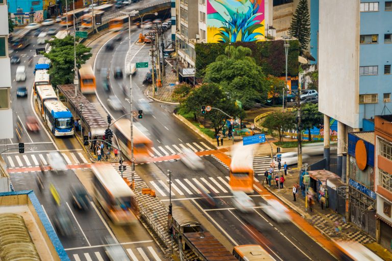 Avenida com trânsito de caros e ônibus