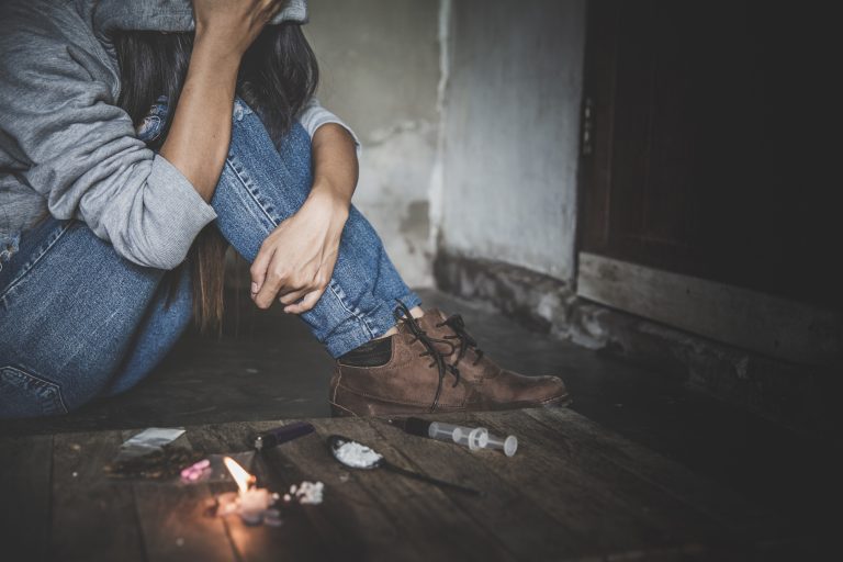 Viciado usa drogas sentado no chão