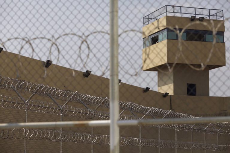 Penitenciária com torre de vigilância e cerca de arame farpado